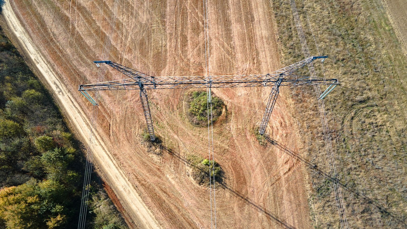 An aerial view of a Bitcoin mining facility next to wind turbines on the Texas plains, with heat shimmer visible on the horizon