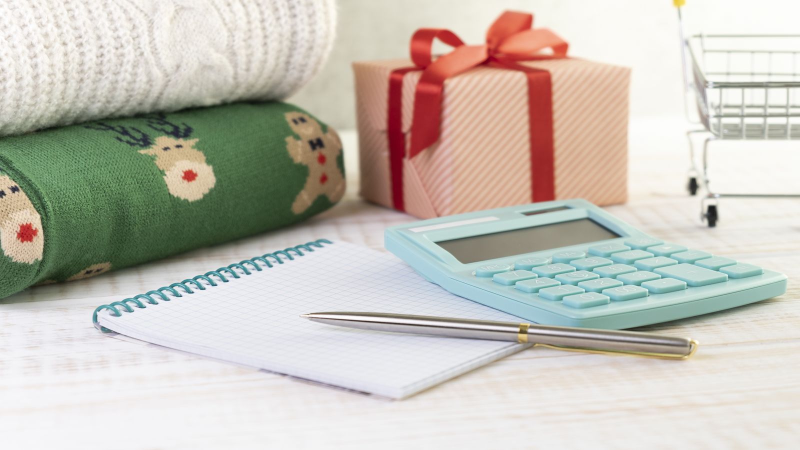 A small wrapped gift beside a handwritten card on a wooden table, simple and intentional, contrasting with the excess of mass consumerism