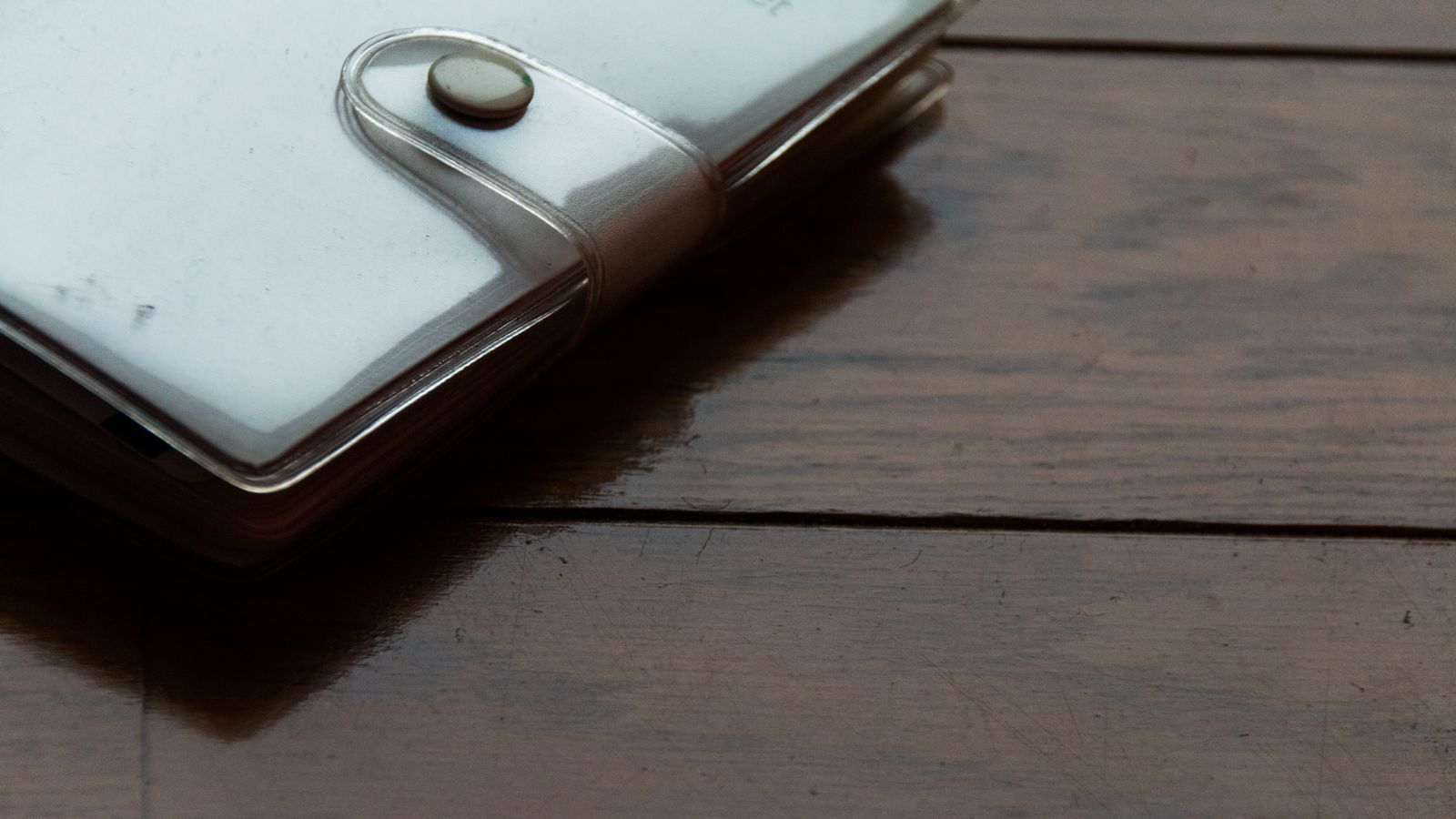 A metal seed phrase backup plate beside a hardware wallet, a fireproof envelope, and a handwritten security checklist on a clean desk