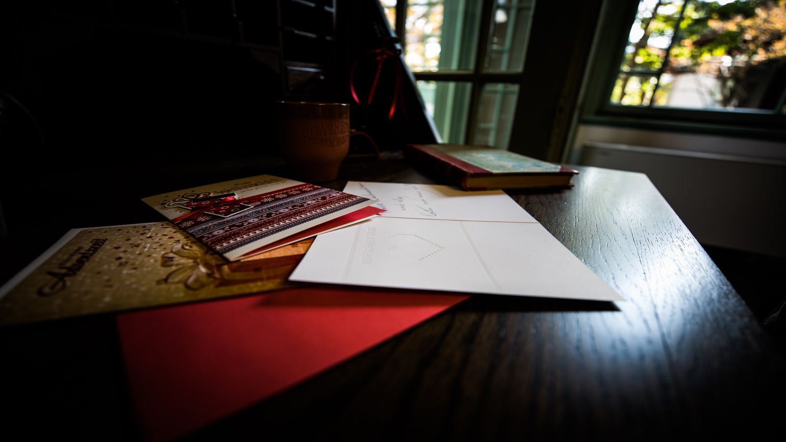 A clean workspace with a red pen, a printed manuscript under review, and a reference stack, representing the editorial review process